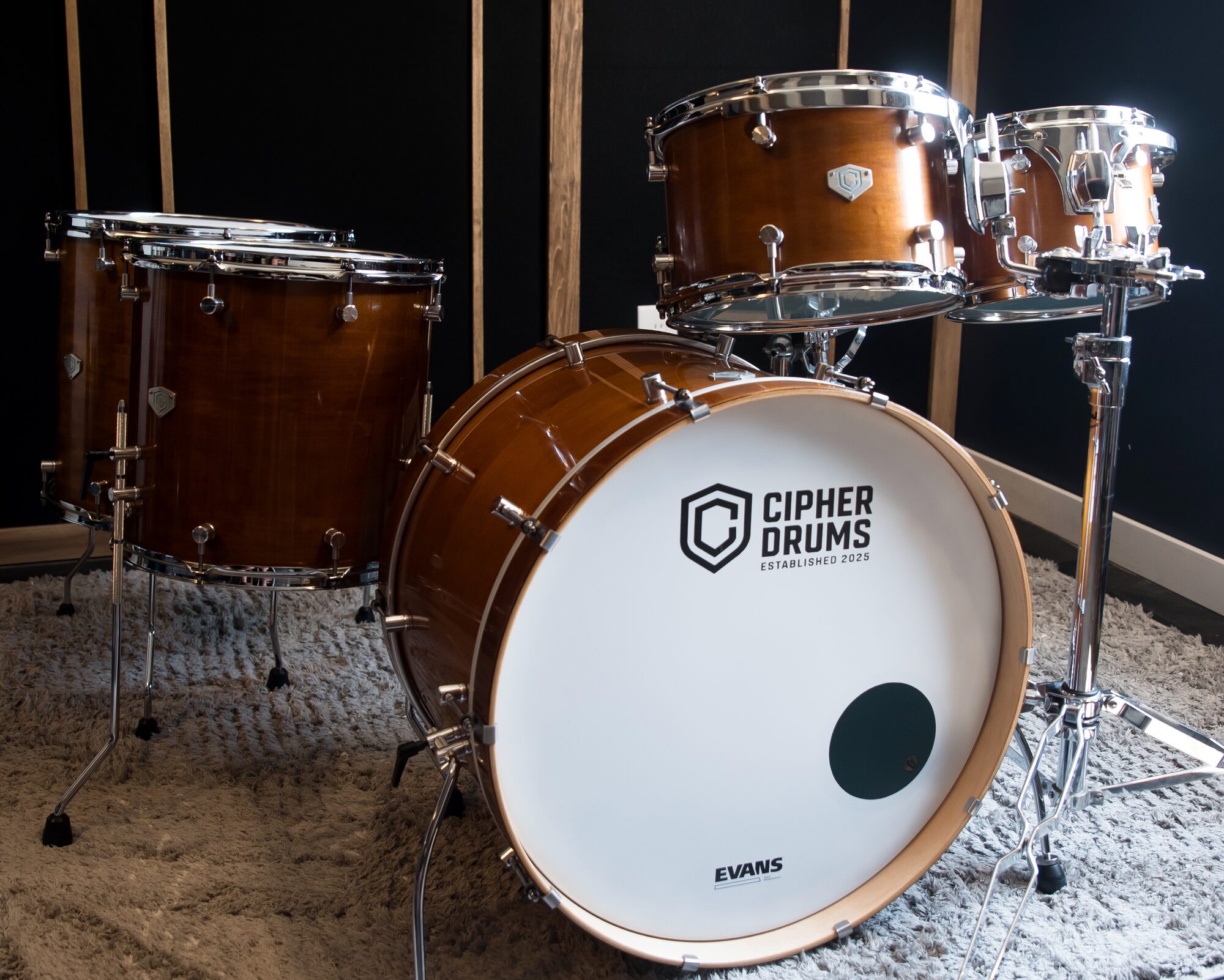 A Cipher Drums kit — honey maple with the Cipher badge on the bass drum