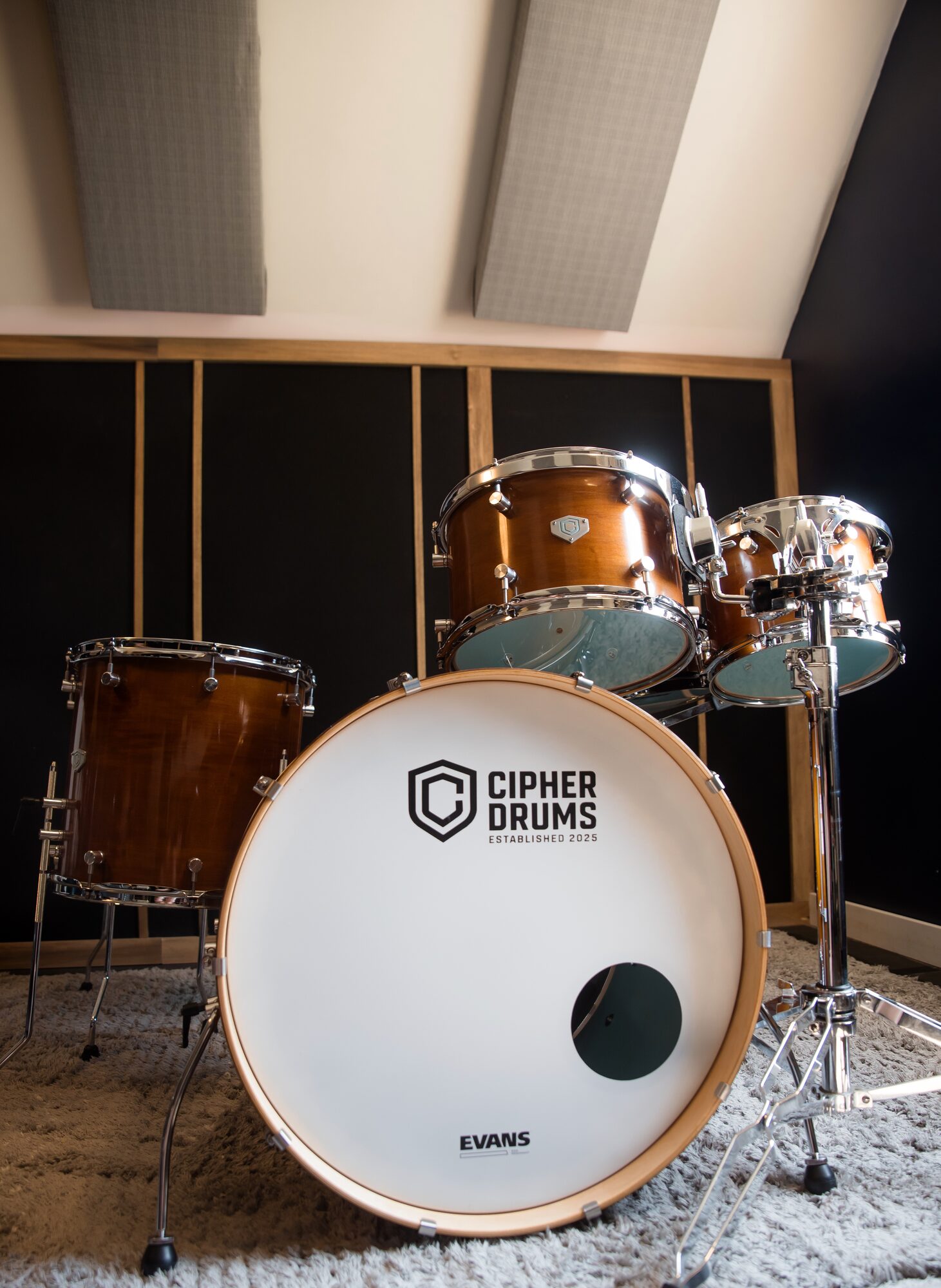 A finished Cipher Drums kit in the workshop — honey maple, portrait