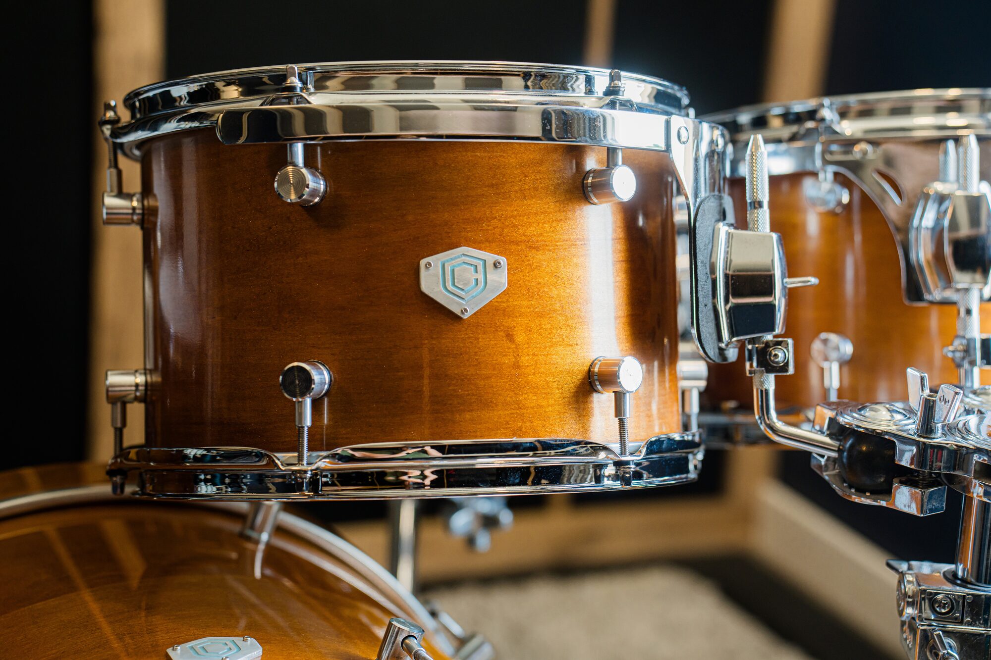Tom close-up with the Cipher badge and honey maple finish